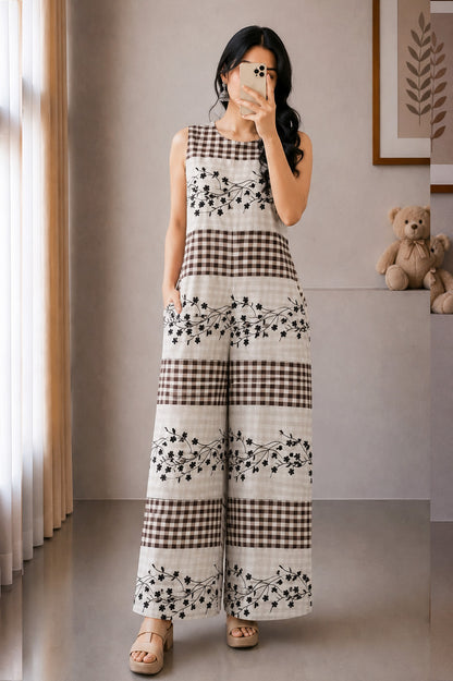 Woman taking a mirror selfie wearing a black and white checkered dress with floral patterns.