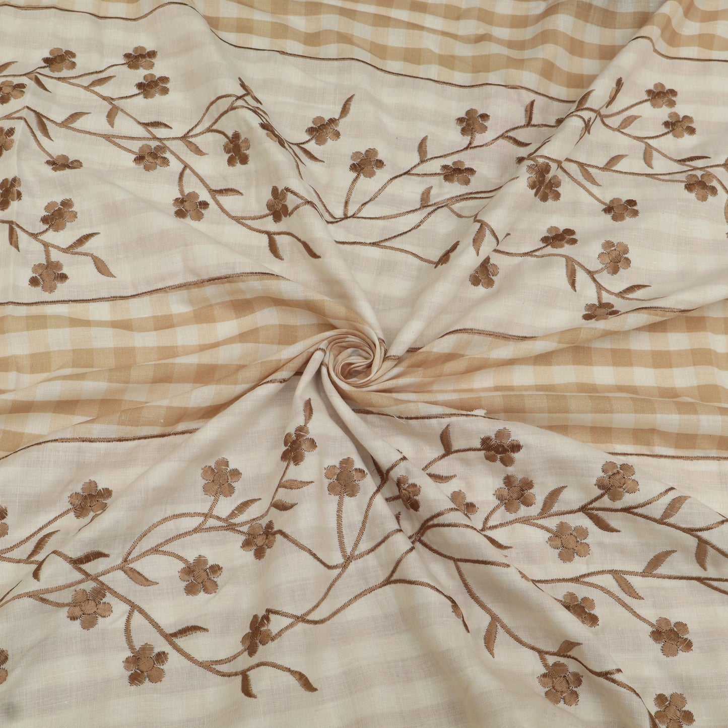 Fabric with brown floral embroidery on a beige and brown checkered background