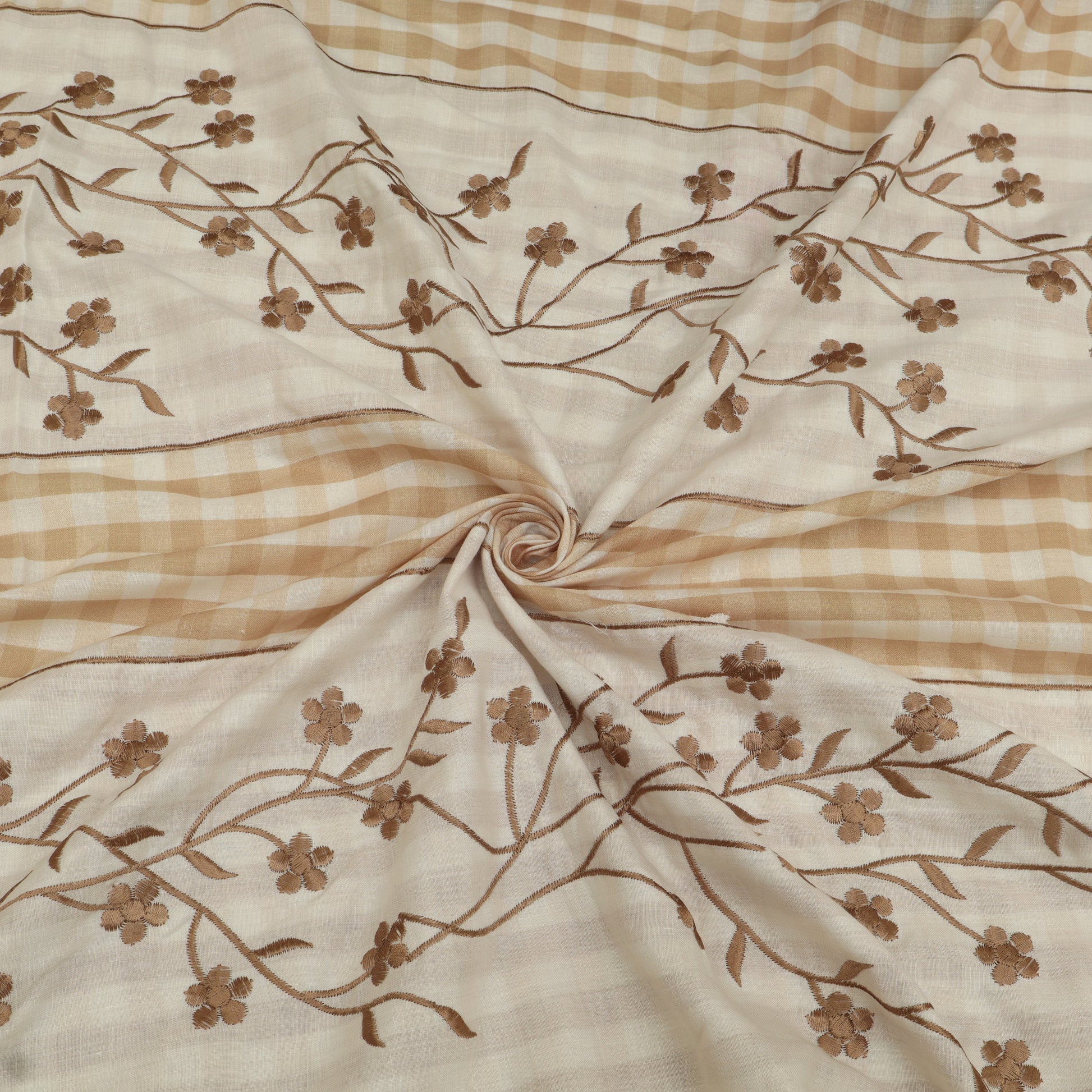 Fabric with brown floral embroidery on a beige and brown checkered background
