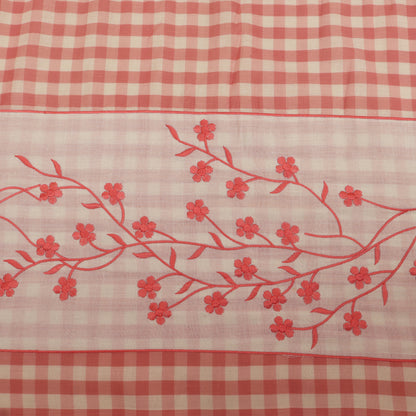 Red floral embroidery on a red and white checkered fabric background