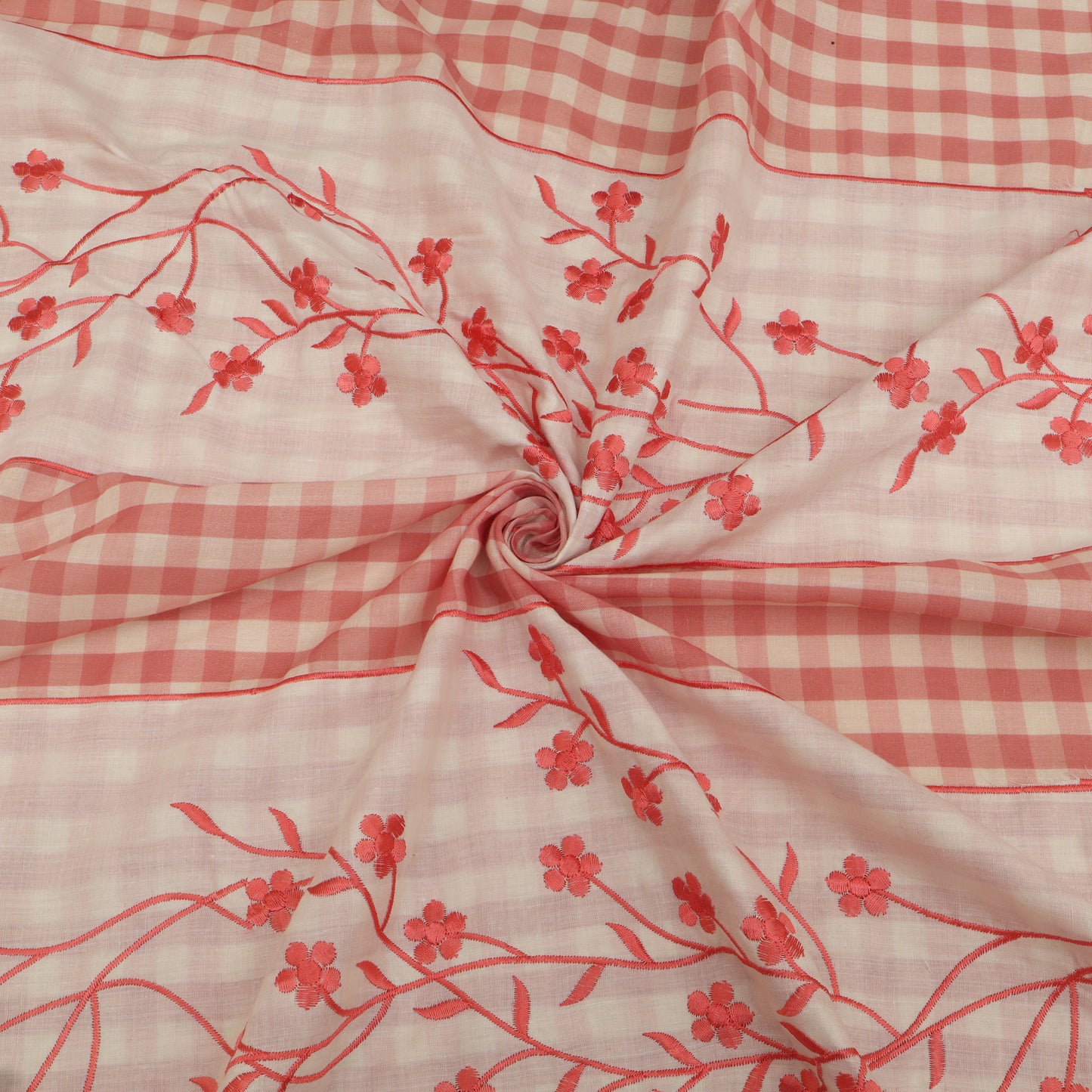 Fabric with red floral patterns on a pink checkered background