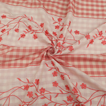 Fabric with red floral patterns on a pink checkered background