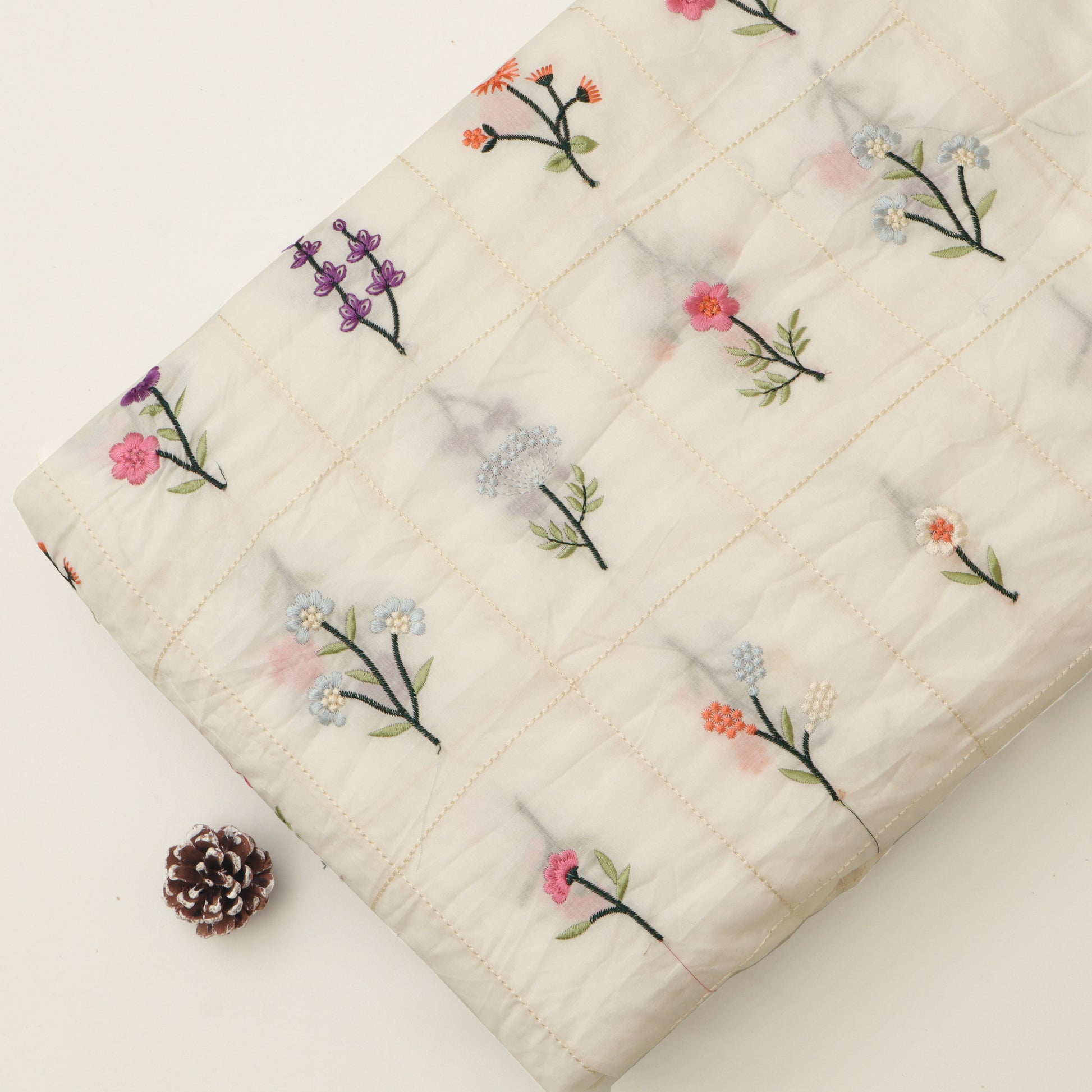 Quilt with floral embroidery on a white background
