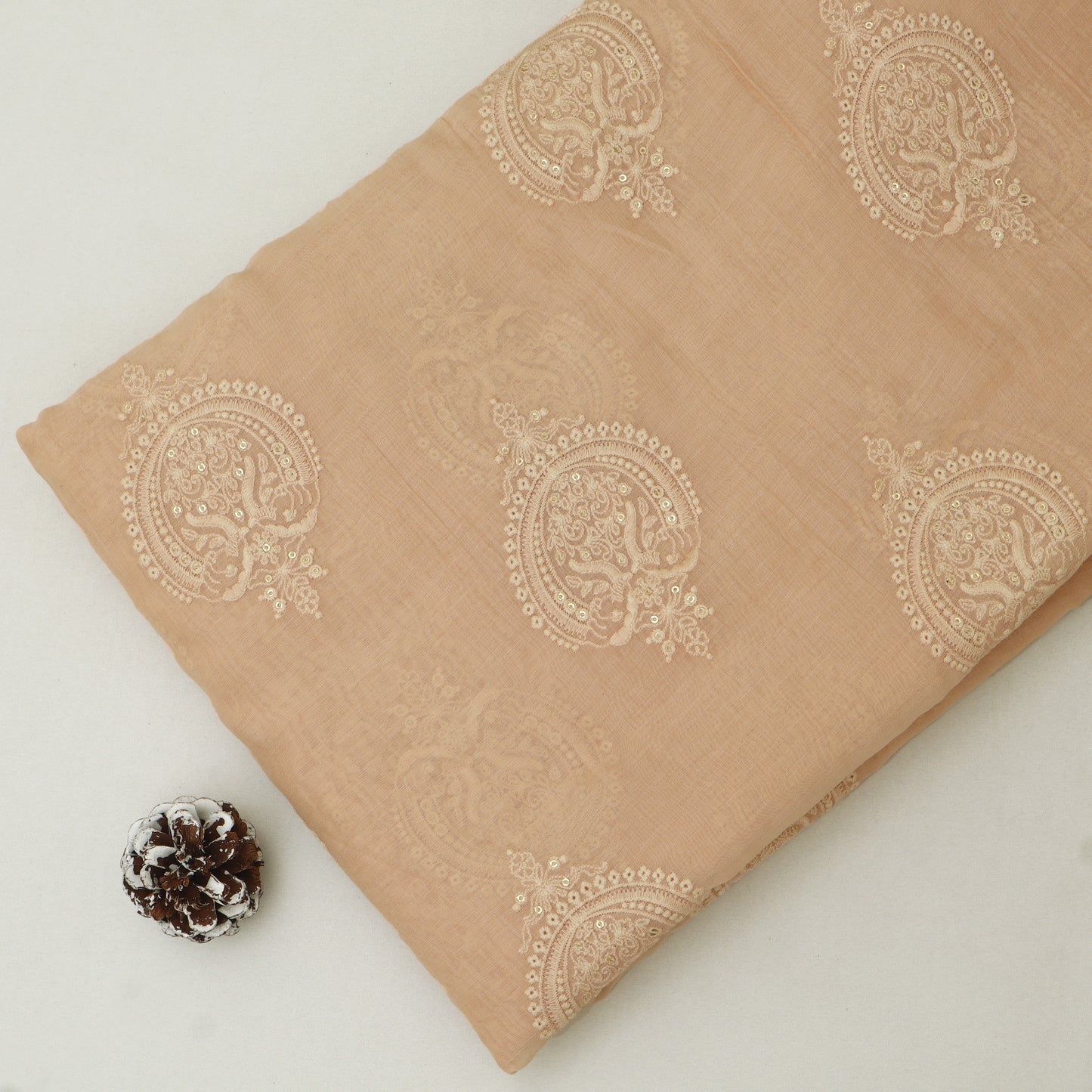 Beige fabric with intricate patterns on a light background