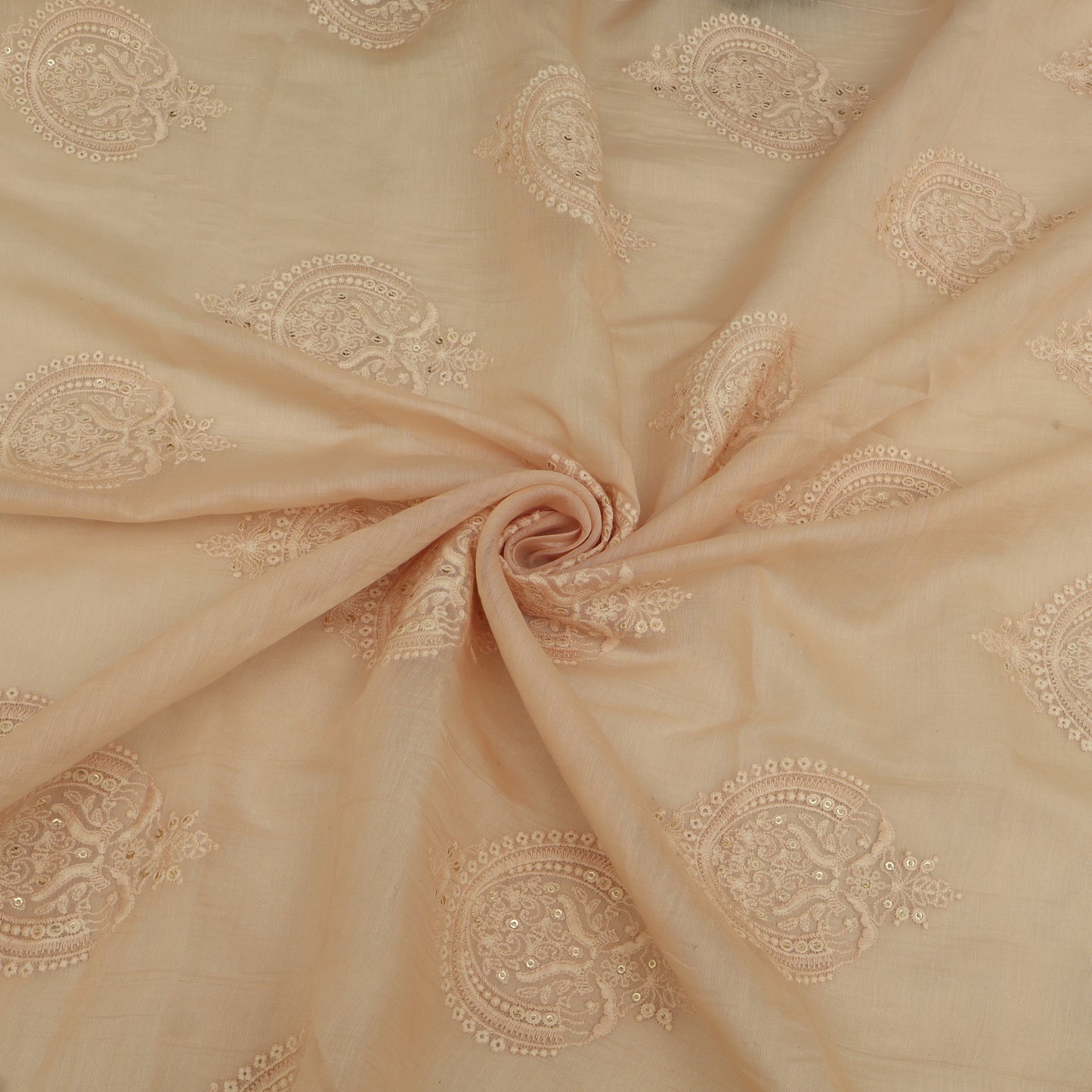 Beige fabric with intricate gold embroidery in a spiral pattern