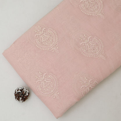 Pink fabric with white floral patterns on a light gray background