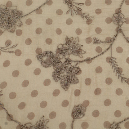 Textile with floral embroidery and polka dot pattern on beige background