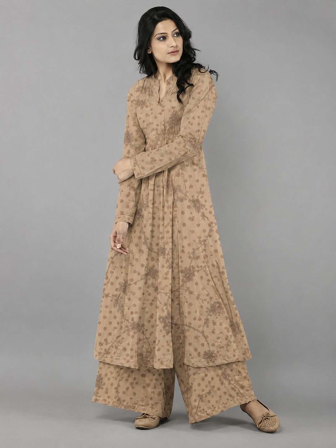 Woman wearing a beige traditional outfit with a plain background