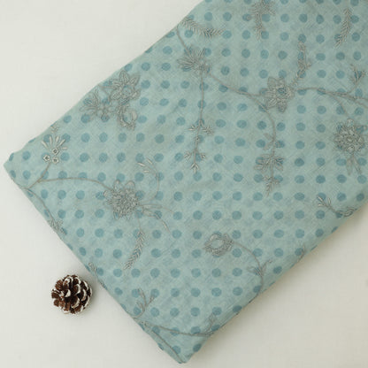 Teal fabric with floral pattern and pine cone on a white background