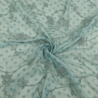 Textured fabric with floral and polka dot patterns on a light blue background