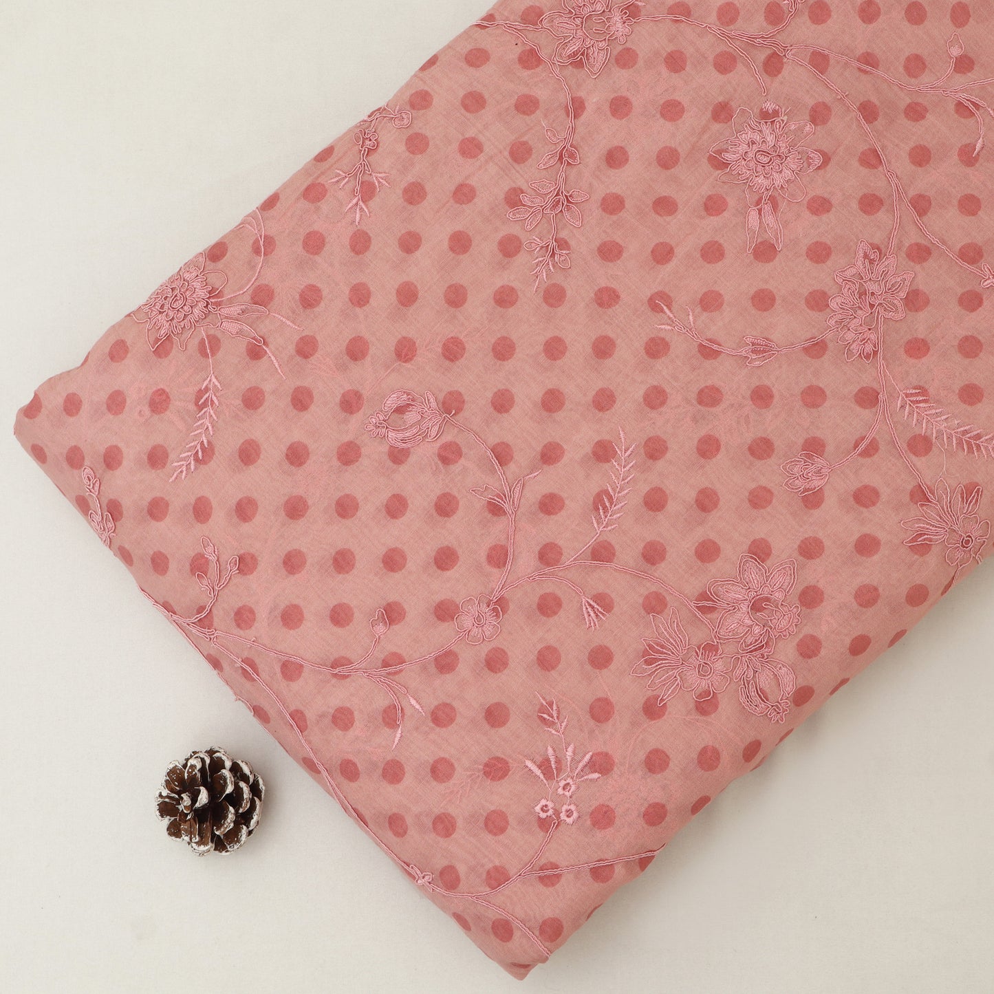 Pink polka dot fabric with floral patterns on a white background