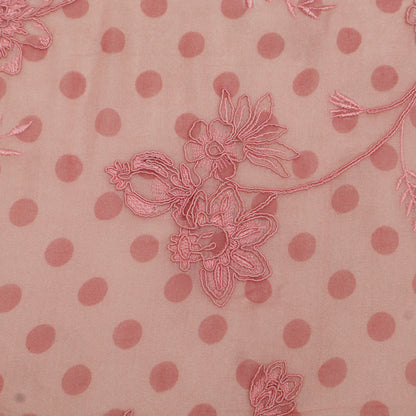 Pink polka dot fabric with floral embroidery on a pink background