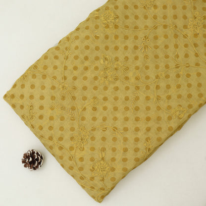 Gold embroidered fabric with a pine cone on a white background