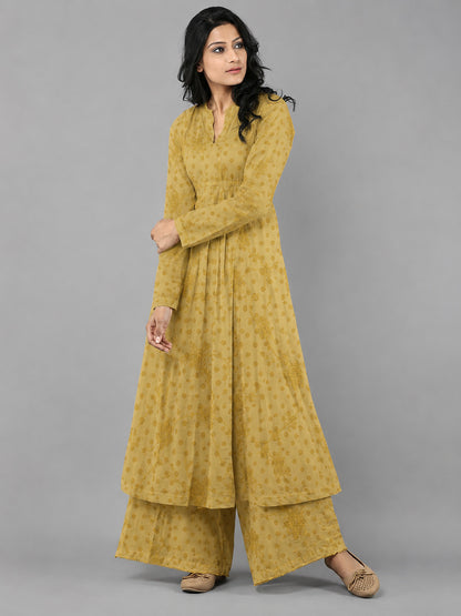 Woman wearing a mustard yellow traditional outfit on a gray background