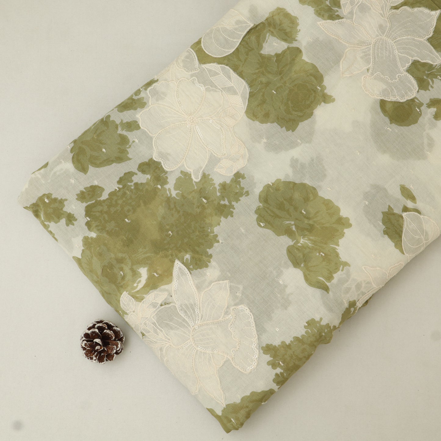 Floral-patterned fabric with green and white flowers on a plain background