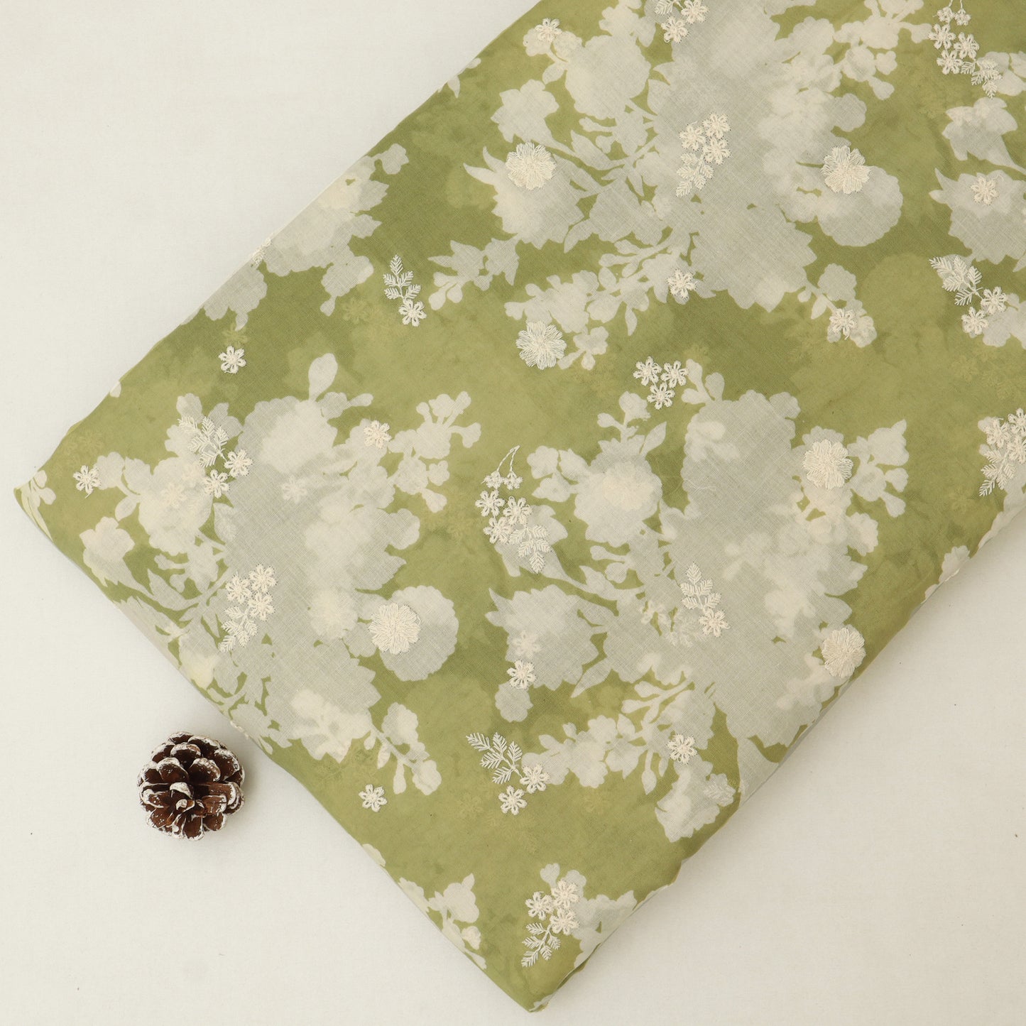 Floral fabric with blue and beige pattern on a white surface