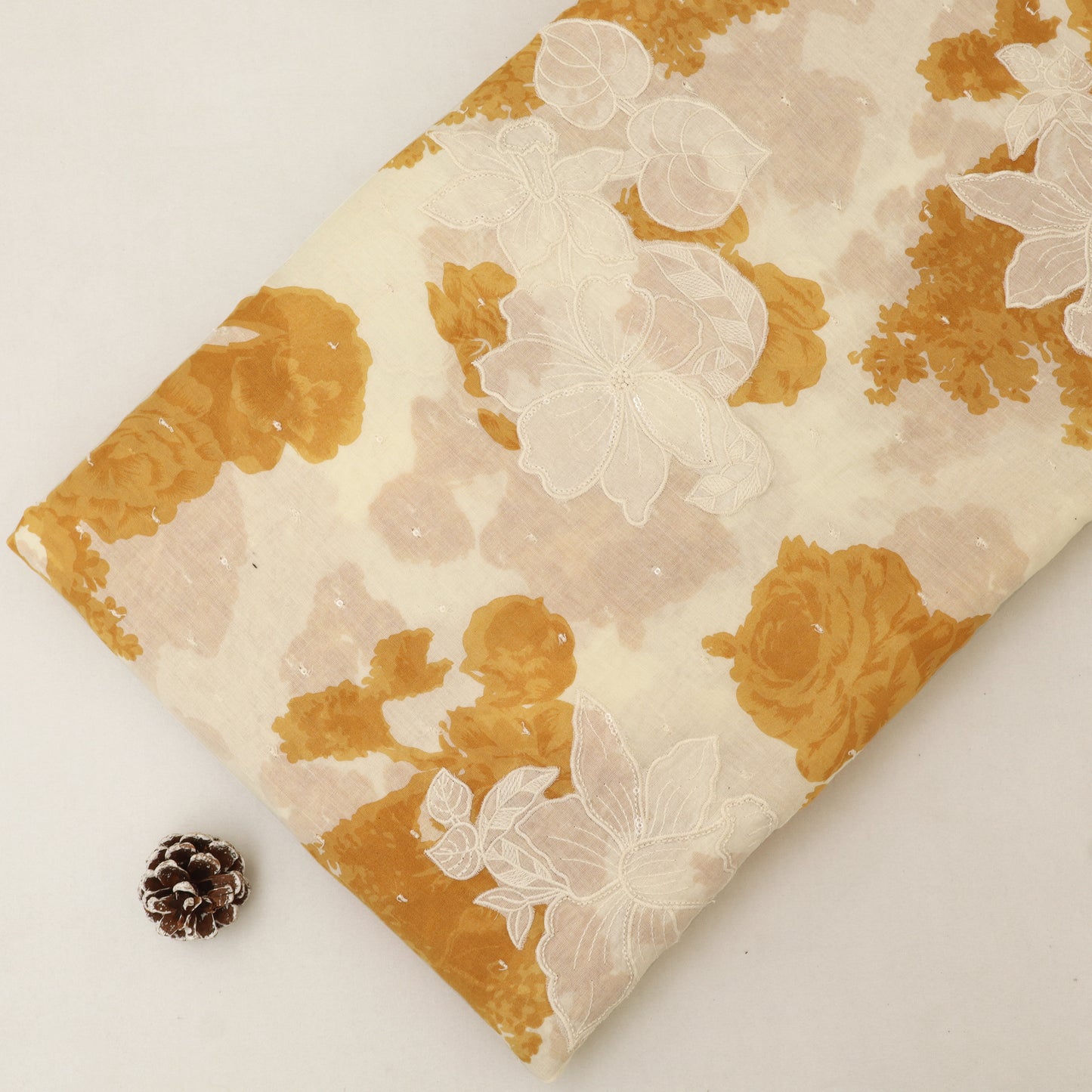 Floral-patterned fabric with gold and beige colors on a white background